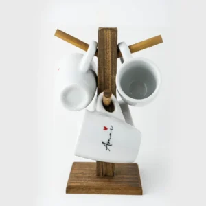 Suporte de madeira com caneca branca amor em destaque e outras canecas penduradas.